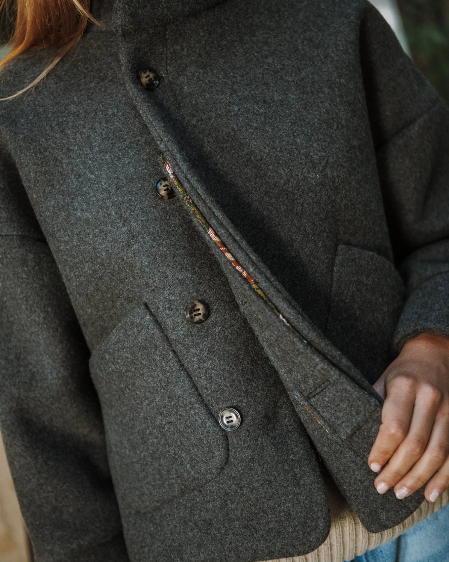 Carole de Maéli, la veste avec sa croisure et ouverture semi-cachée boutonnée.