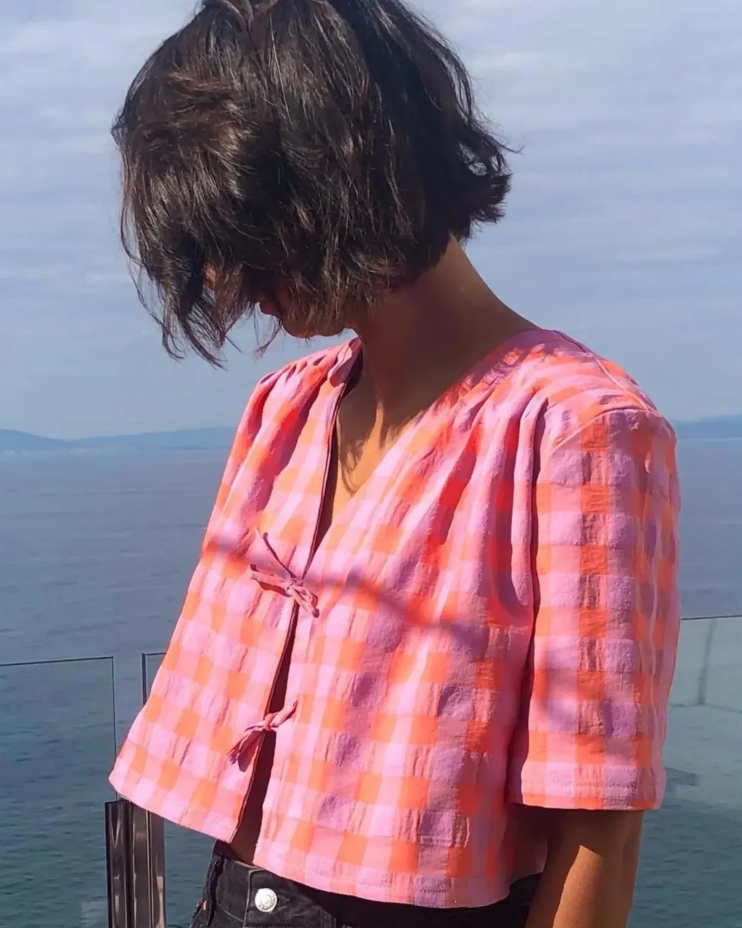 Chemisette Sacha rose avec col V, plis plats et liens décoratifs.