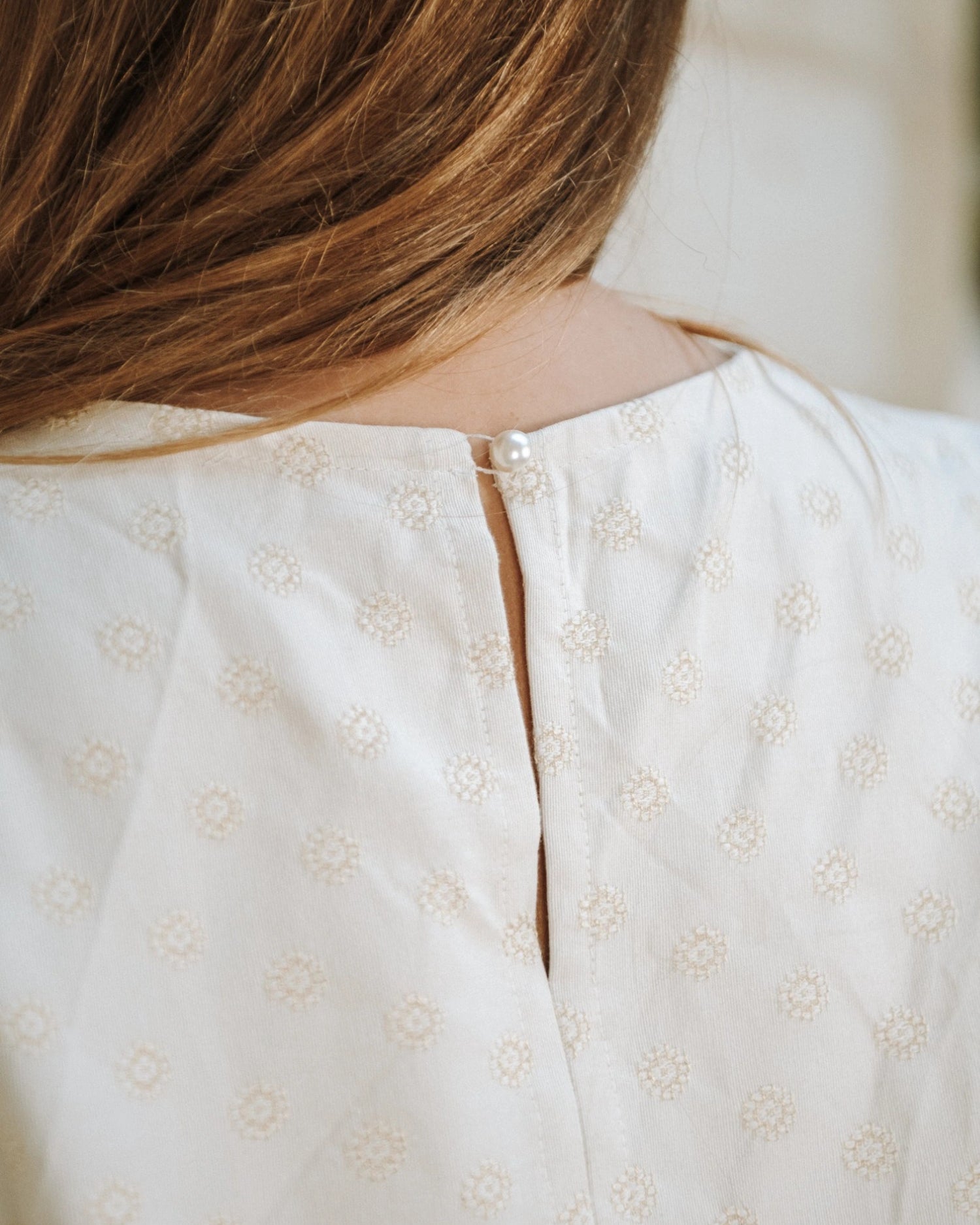 La blouse Chloé avec sa fermeture à bouton dans le dos.