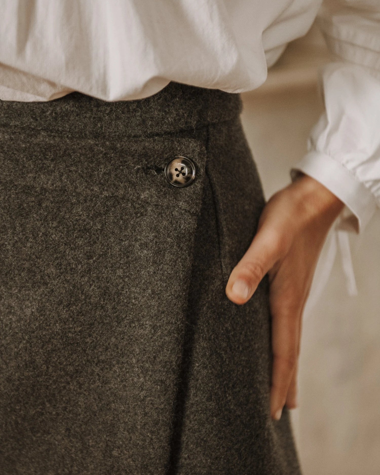 Une jupe courte en lainage gris avec bouton latéral, patron Lisa de Maéli Paris.