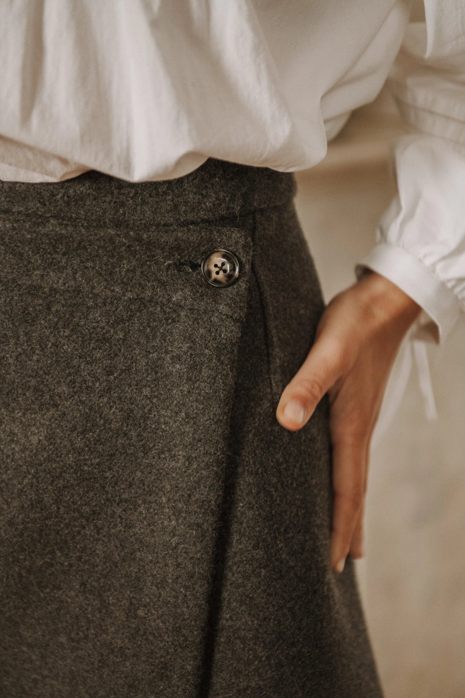 Une jupe courte en lainage gris avec bouton latéral, patron Lisa de Maéli Paris.
