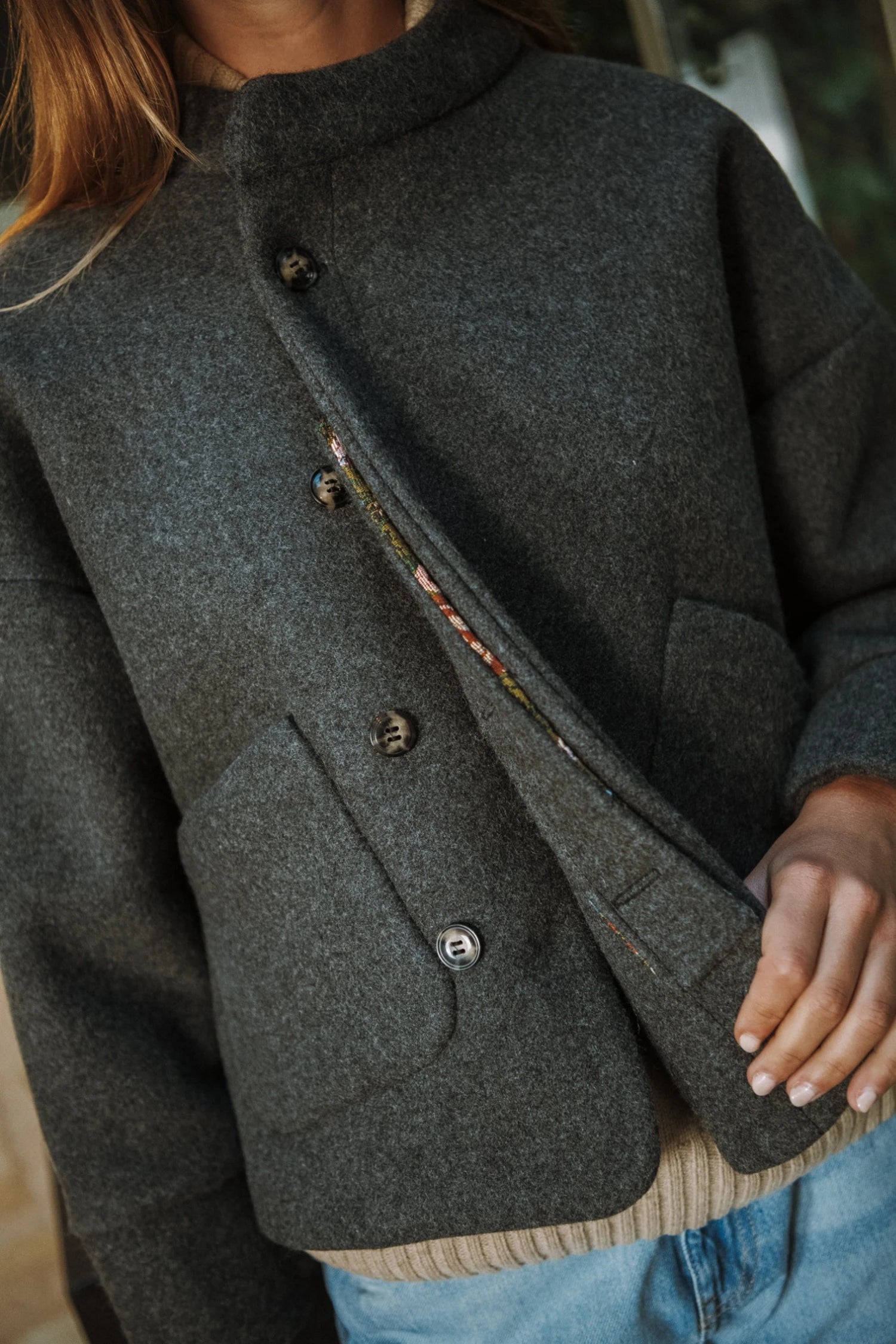 Carole de Maéli, la veste avec sa croisure et ouverture semi-cachée boutonnée.