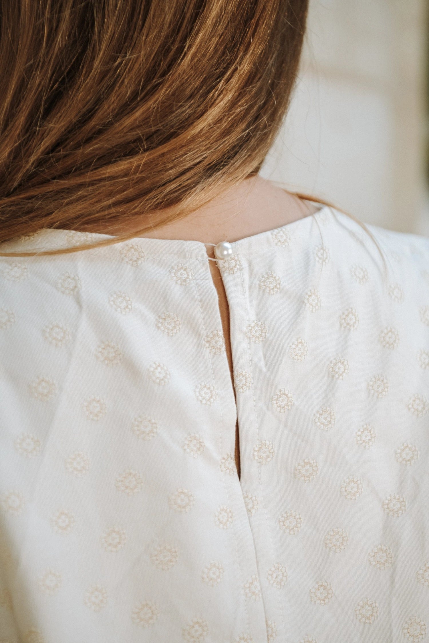 La blouse Chloé avec sa fermeture à bouton dans le dos.